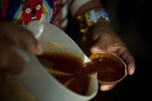 person pouring substance from bowl into mug
